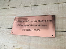 Polished copper sign with custom text.