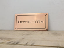 Bronze metal pool depth sign.