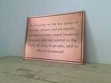 Copper business plaque with engraved motto and border.