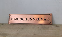Copper nameplate with engraved name and border.