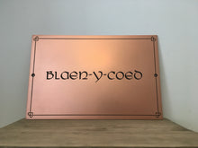 Copper house sign with Celtic lettering and border design.