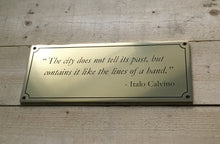 Gold coloured (brass) plaque with custom engraved quote and border on a wooden surface - made by 3Dprintshed