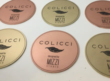 Round copper and brass discs with engraved text and logo, circular metal plaques.